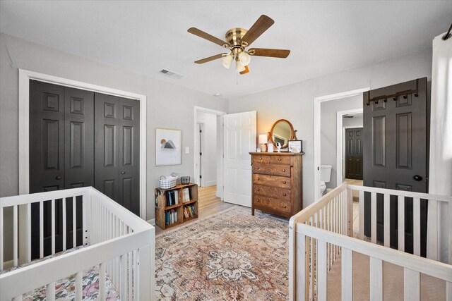 bedroom featuring a nursery area and ceiling fan