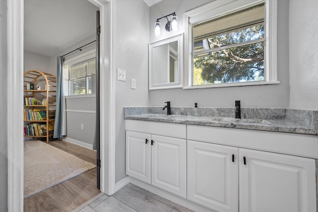 300 L S P Cir, Kerens, TX 75144 - bathroom featuring double vanity, baseboards, and wood finished floors