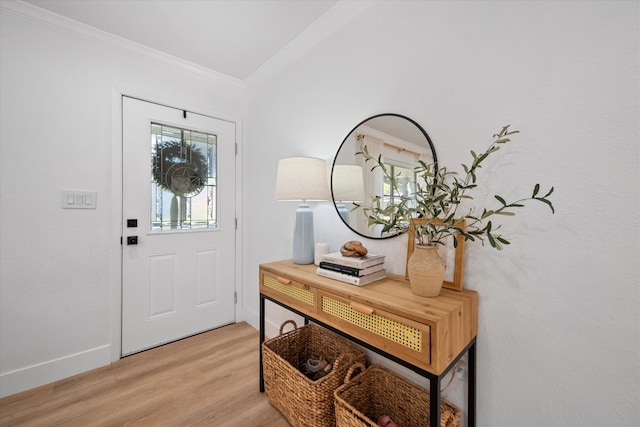 entrance foyer with ornamental molding and light wood-type flooring