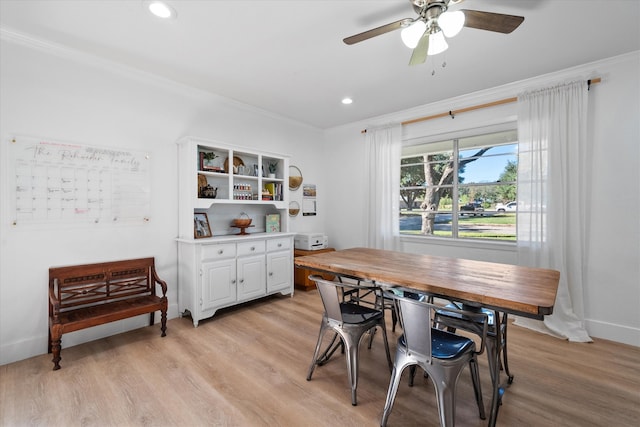 dining area with crown molding, ceiling fan, and light wood-type flooring