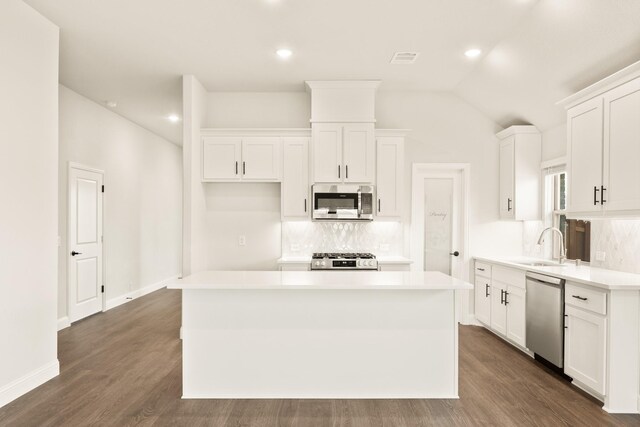 kitchen featuring appliances with stainless steel finishes, light hardwood / wood-style flooring, lofted ceiling, and sink