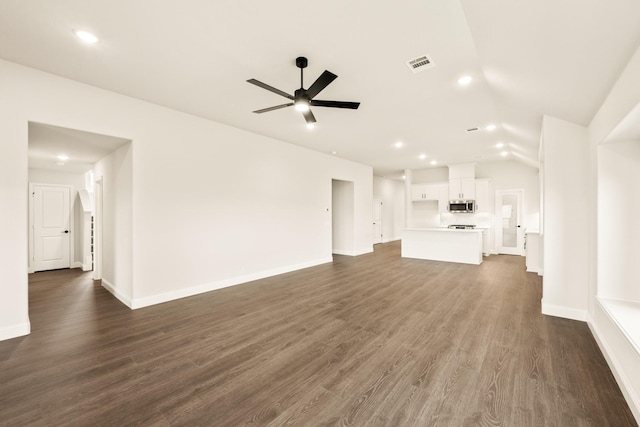 unfurnished living room with dark hardwood / wood-style flooring, vaulted ceiling, and ceiling fan