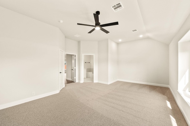 spare room with light carpet, vaulted ceiling, and ceiling fan