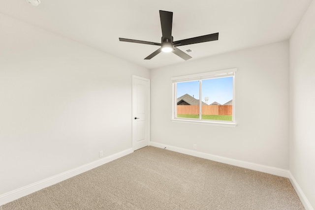 unfurnished room with ceiling fan and carpet