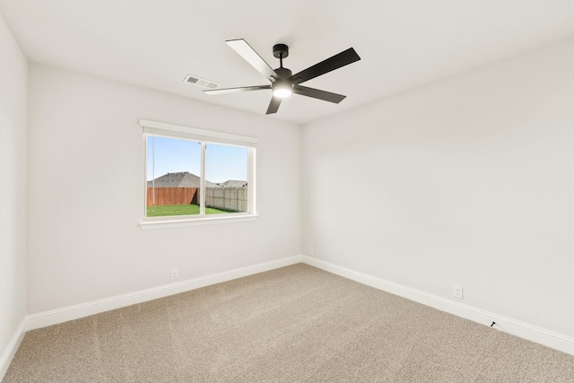 unfurnished room with ceiling fan and carpet