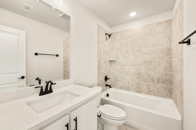 full bathroom with tiled shower / bath, vanity, and toilet