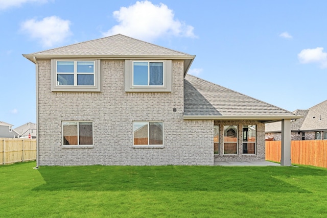 rear view of house with a yard and a patio area