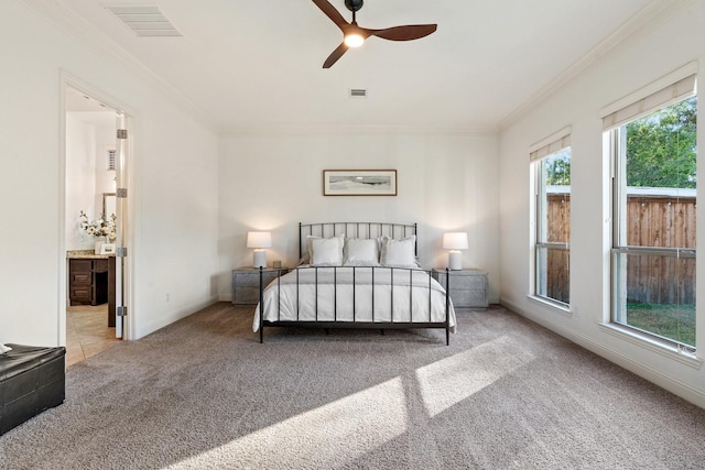 carpeted bedroom featuring ceiling fan, crown molding, and connected bathroom