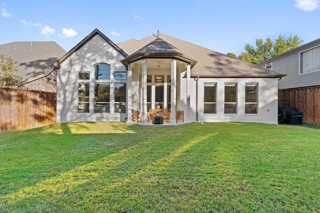 rear view of house with a lawn and ceiling fan