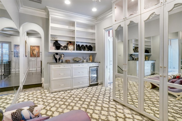 2009 E Highland St, Southlake, TX 76092 - indoor bar featuring beverage cooler, crown molding, arched walkways, light colored carpet, and built in features