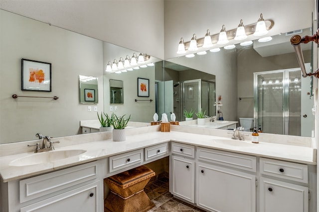 bathroom with vanity, toilet, and a shower with door