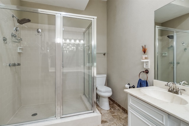 bathroom featuring vanity, toilet, and a shower with shower door