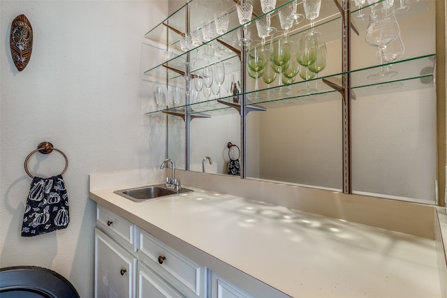 bar with white cabinetry and sink