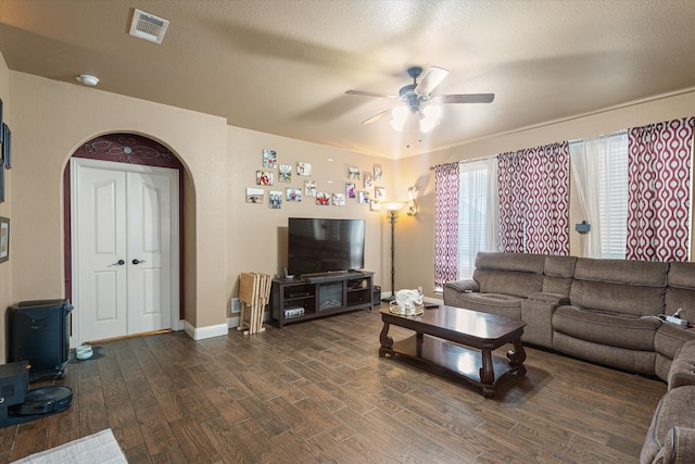 living room featuring a textured ceiling, dark hardwood / wood-style flooring, and ceiling fan