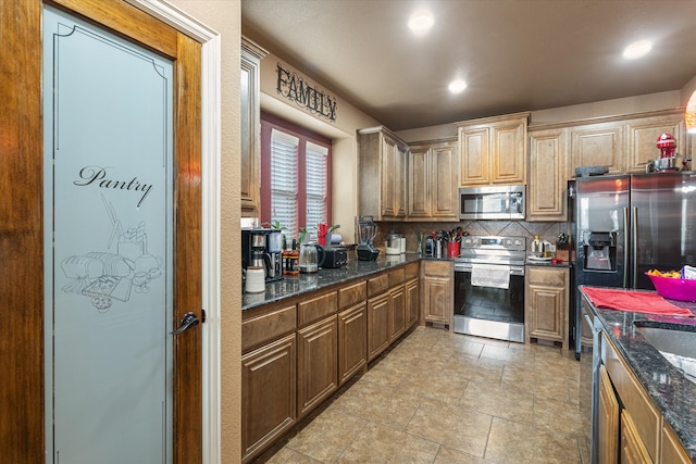 kitchen with dark stone counters, appliances with stainless steel finishes, and tasteful backsplash