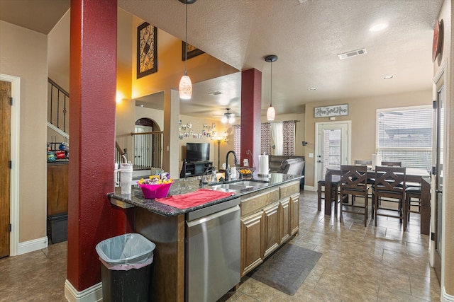 kitchen featuring dishwasher, pendant lighting, a textured ceiling, and sink