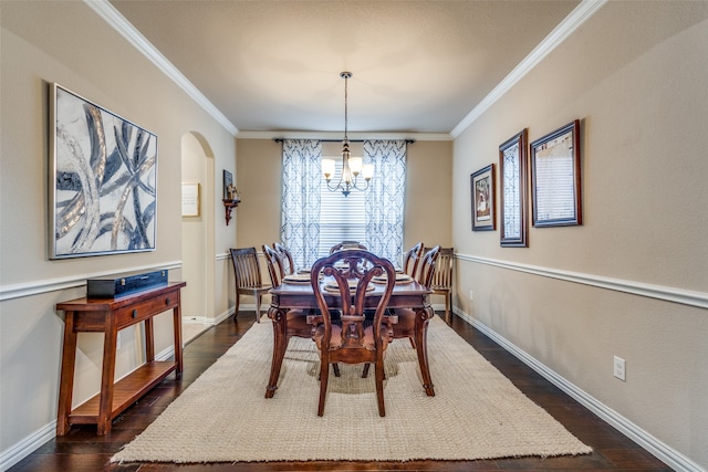 dining space featuring crown molding, dark hardwood / wood-style flooring, and an inviting chandelier