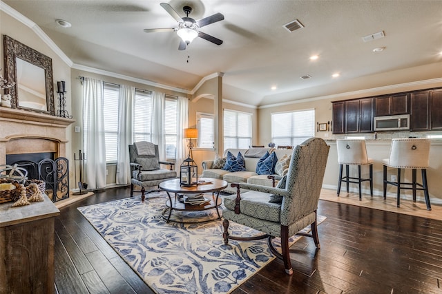 living room with ceiling fan, dark hardwood / wood-style flooring, and ornamental molding