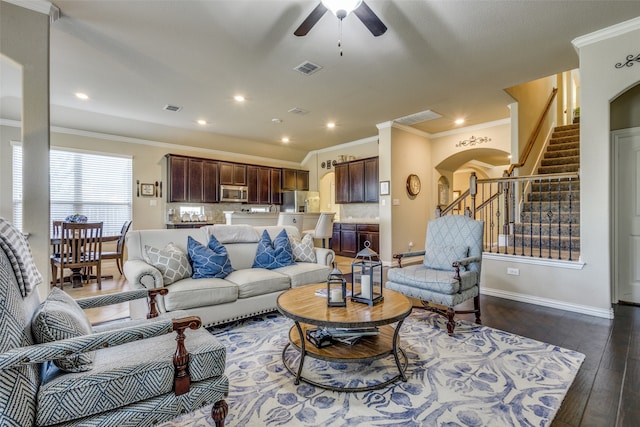 living room with ceiling fan, ornamental molding, and dark wood-type flooring