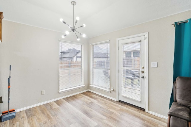 dining room featuring plenty of natural light, an inviting chandelier, and light hardwood / wood-style flooring