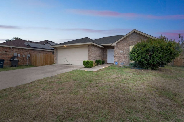 ranch-style home featuring a yard and a garage