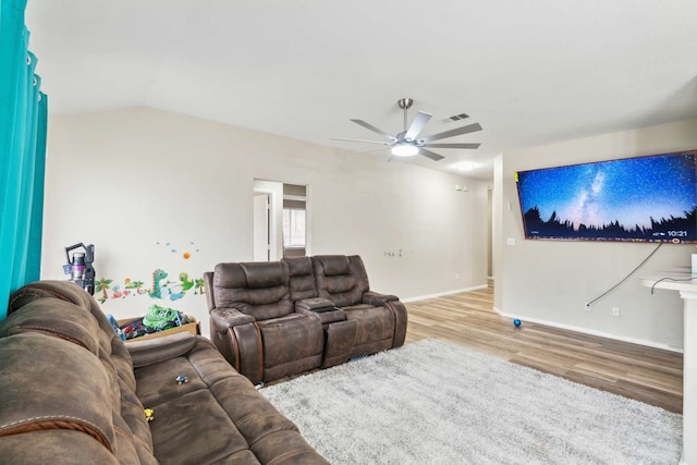 living room with ceiling fan, light hardwood / wood-style floors, and vaulted ceiling