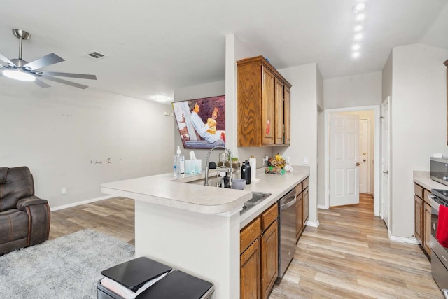 kitchen featuring ceiling fan, sink, stainless steel appliances, kitchen peninsula, and light hardwood / wood-style floors