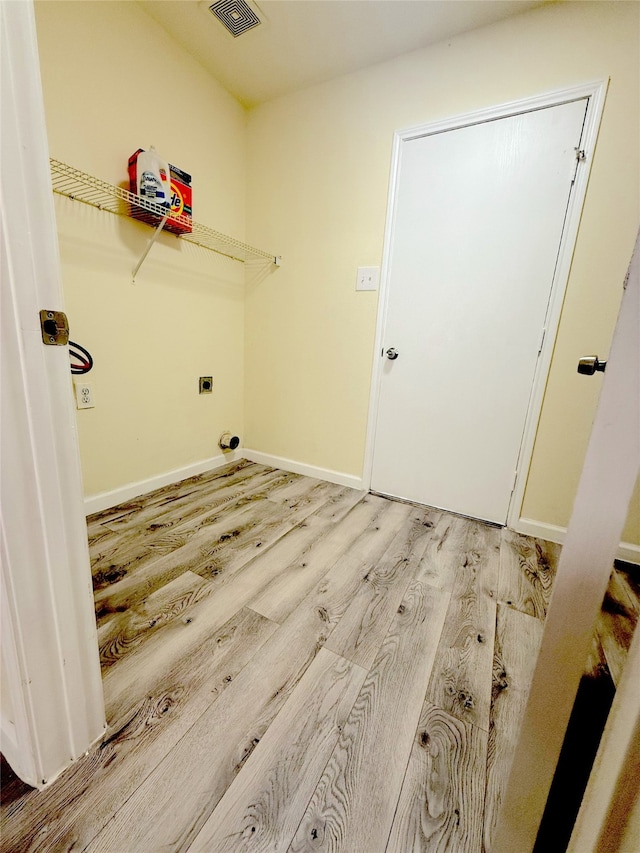 clothes washing area with hookup for an electric dryer and light hardwood / wood-style flooring