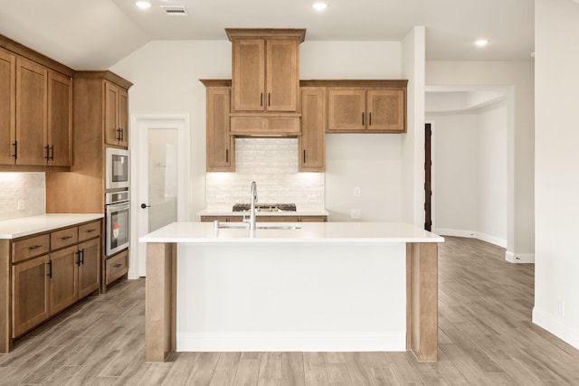 kitchen with visible vents, appliances with stainless steel finishes, brown cabinets, and light countertops