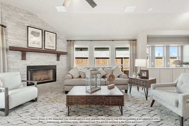 living room with plenty of natural light, ceiling fan, a fireplace, and vaulted ceiling