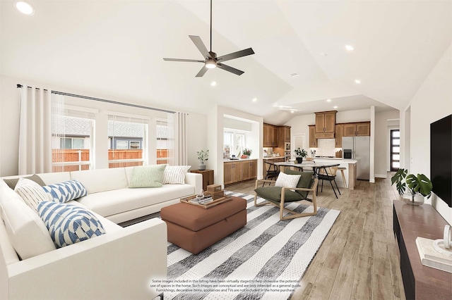 living room with light wood-style floors, recessed lighting, ceiling fan, and high vaulted ceiling