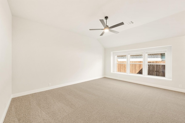 empty room with carpet, lofted ceiling, visible vents, ceiling fan, and baseboards