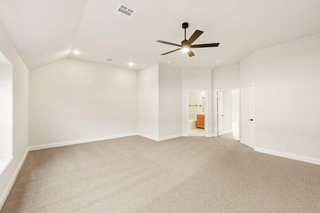 carpeted spare room featuring lofted ceiling, ceiling fan, visible vents, and baseboards