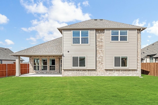 back of house featuring a patio area, brick siding, and a lawn