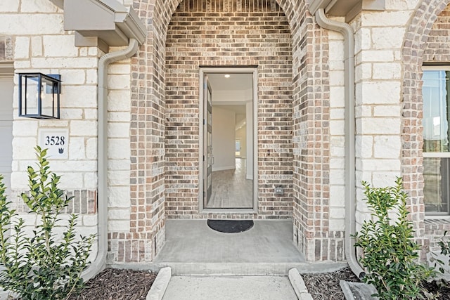 view of exterior entry featuring brick siding