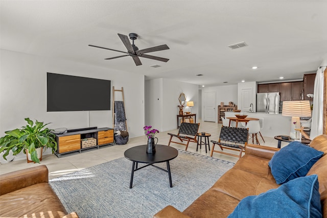 living room featuring ceiling fan, light tile patterned floors, and sink