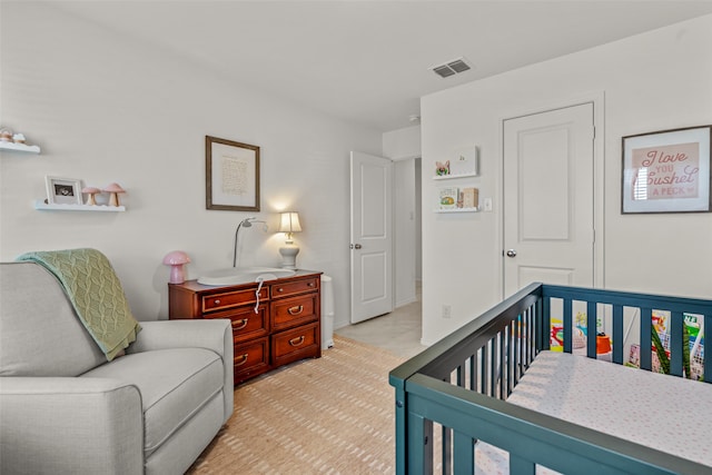 bedroom featuring light tile patterned flooring and a crib