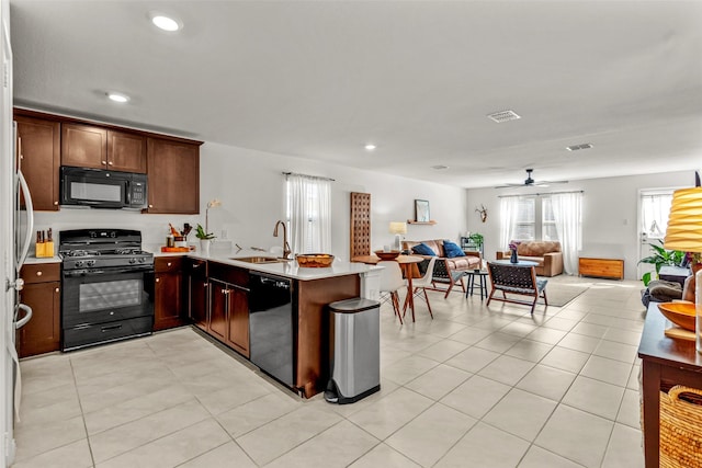 kitchen with light tile patterned floors, kitchen peninsula, ceiling fan, black appliances, and sink