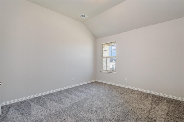 spare room featuring carpet and lofted ceiling