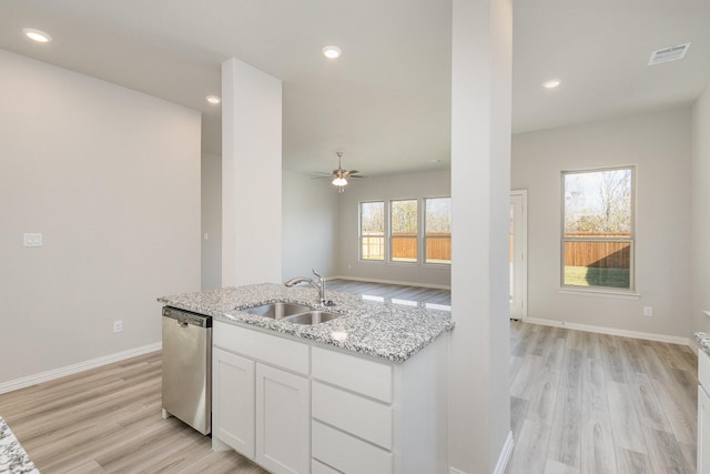 kitchen with light stone countertops, dishwasher, sink, white cabinets, and light wood-type flooring