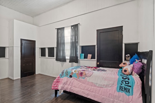 bedroom with dark wood-style floors and baseboards