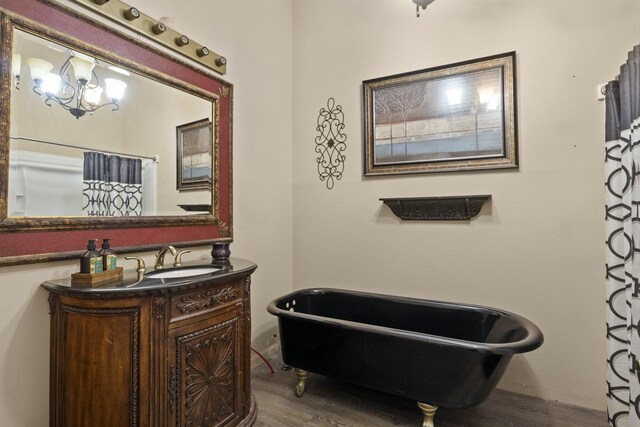 full bath featuring a freestanding tub, wood finished floors, and vanity