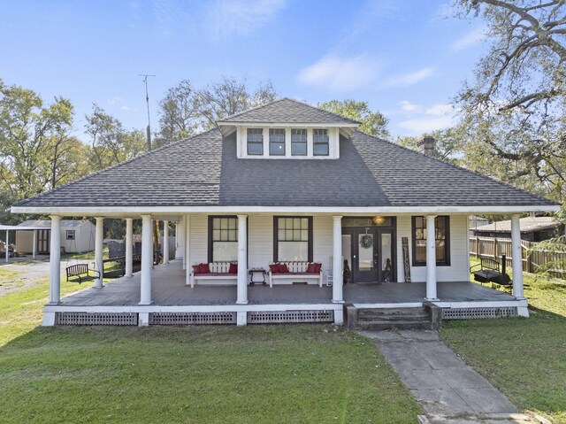 view of front of property with a shingled roof, fence, a front lawn, and a porch