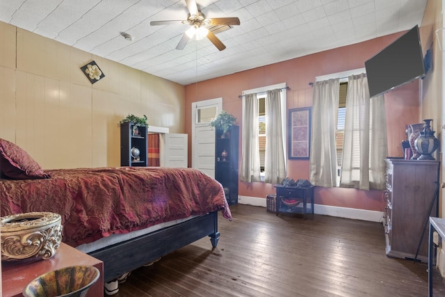 bedroom with ceiling fan, baseboards, and dark wood finished floors