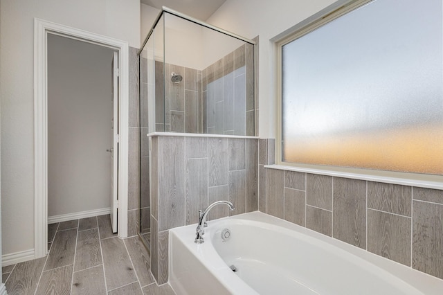 bathroom with wood-type flooring and plus walk in shower