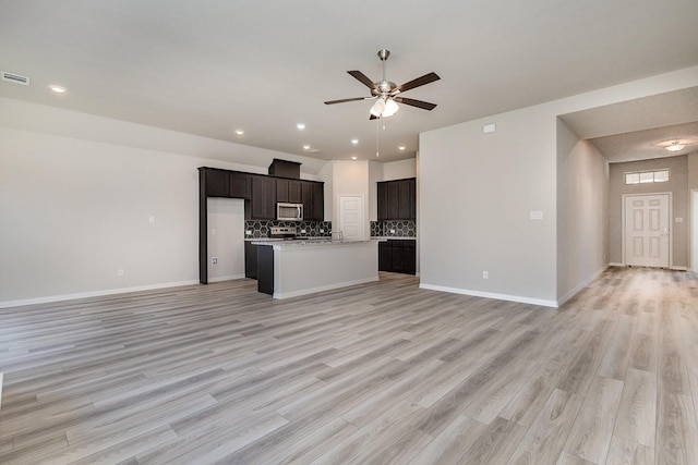 unfurnished living room featuring ceiling fan and light wood-type flooring