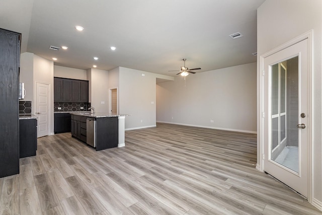 kitchen with backsplash, sink, a center island with sink, light hardwood / wood-style flooring, and dishwasher