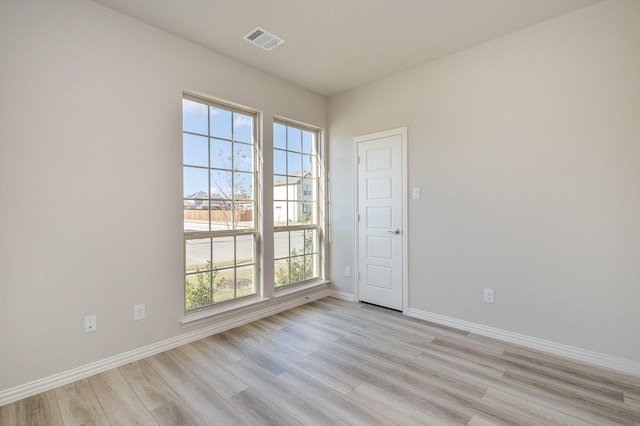 spare room featuring light hardwood / wood-style flooring and a healthy amount of sunlight