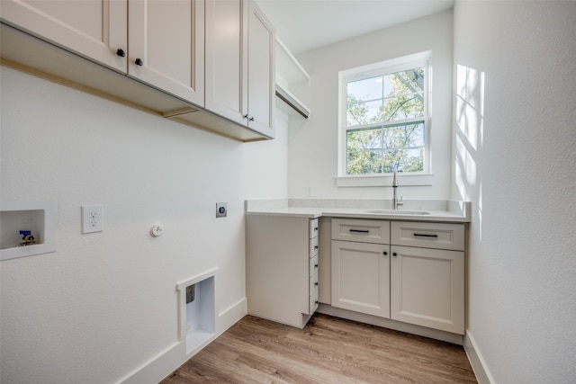 laundry room with sink, cabinets, electric dryer hookup, hookup for a washing machine, and light wood-type flooring