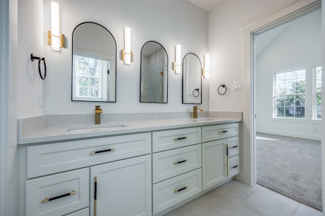 bathroom with tile patterned flooring, vanity, a healthy amount of sunlight, and vaulted ceiling